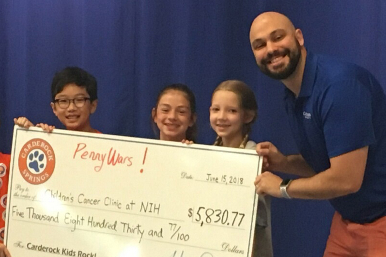 Students hold up a super-sized check.