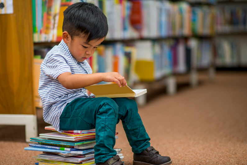 child reads a book in a library
