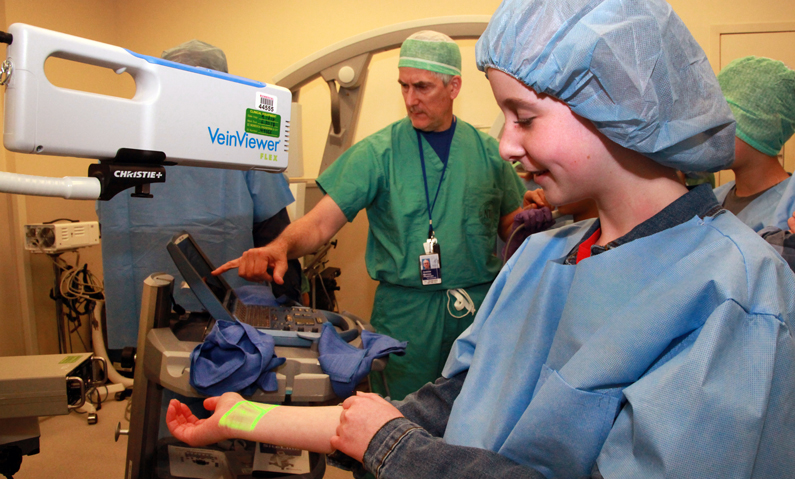 children placed their wrists under a vein viewer for vein illumination