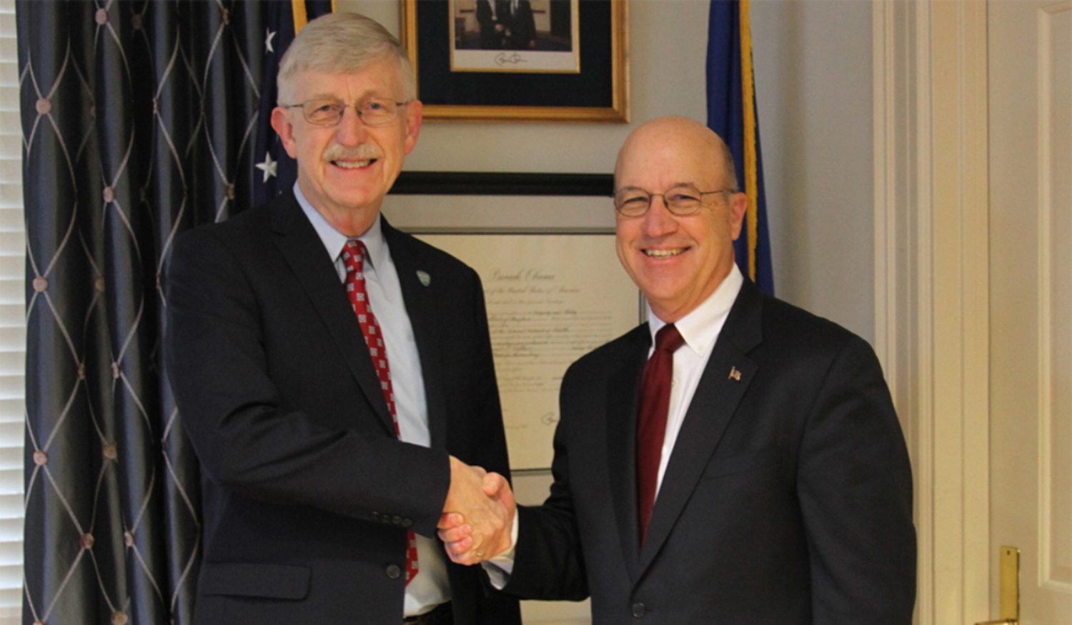 NIH Director Dr. Francis Collins and new NIH Clinical Center CEO Dr. James K. Gilman shake hands after the Jan. 9, 2017, swearing in