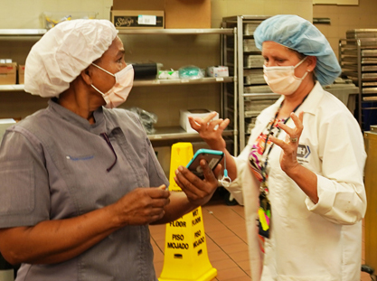 two staff in a food prep area