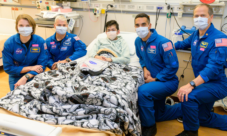 Four astronauts pose with Clinical Center patient Alex