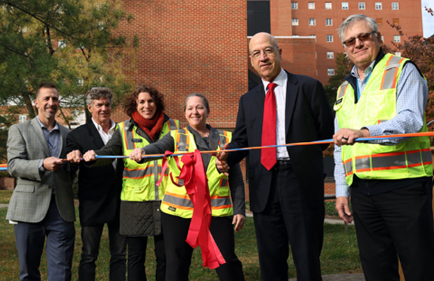 six individuals cut ribbon at ceremony