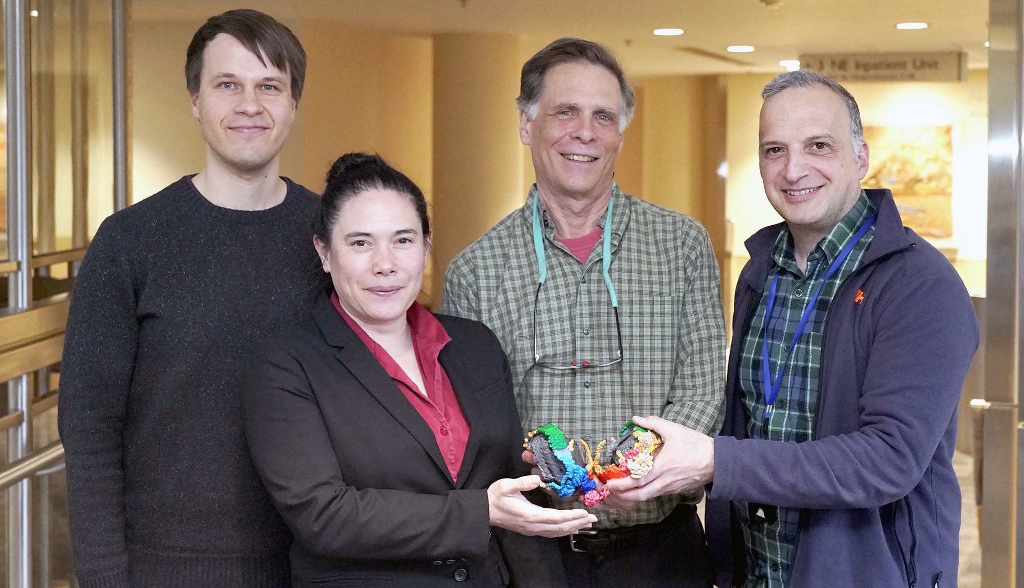 Scientists holding a model of a new molecule