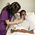 caretaker assisting patient with oxygen mask