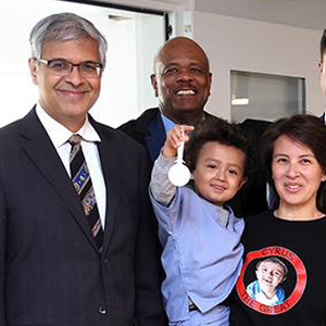 NIH Director Dr. Jay Bhattacharya poses with a pediatric patient and his mother