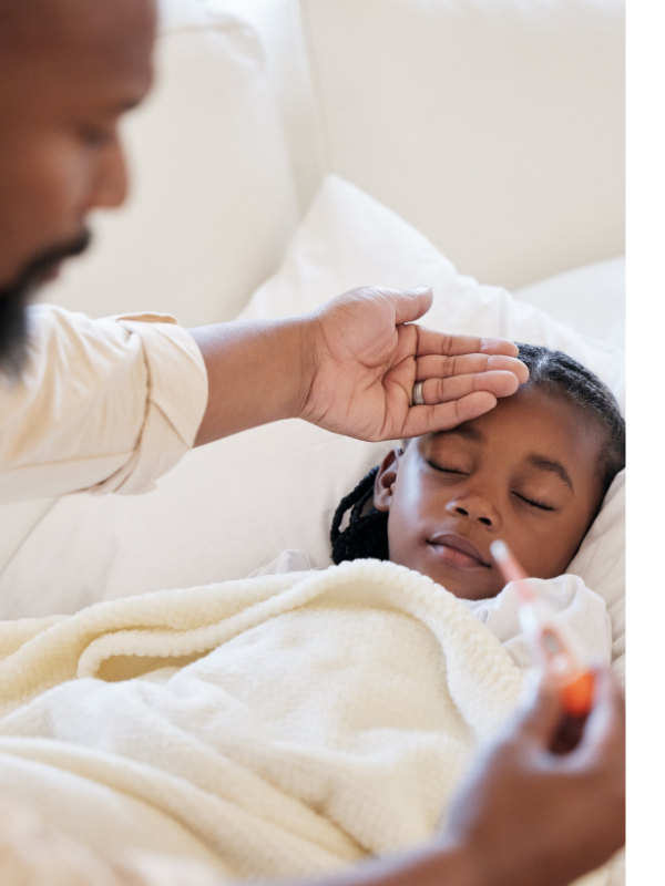 Child in bed with caregiver taking temperature