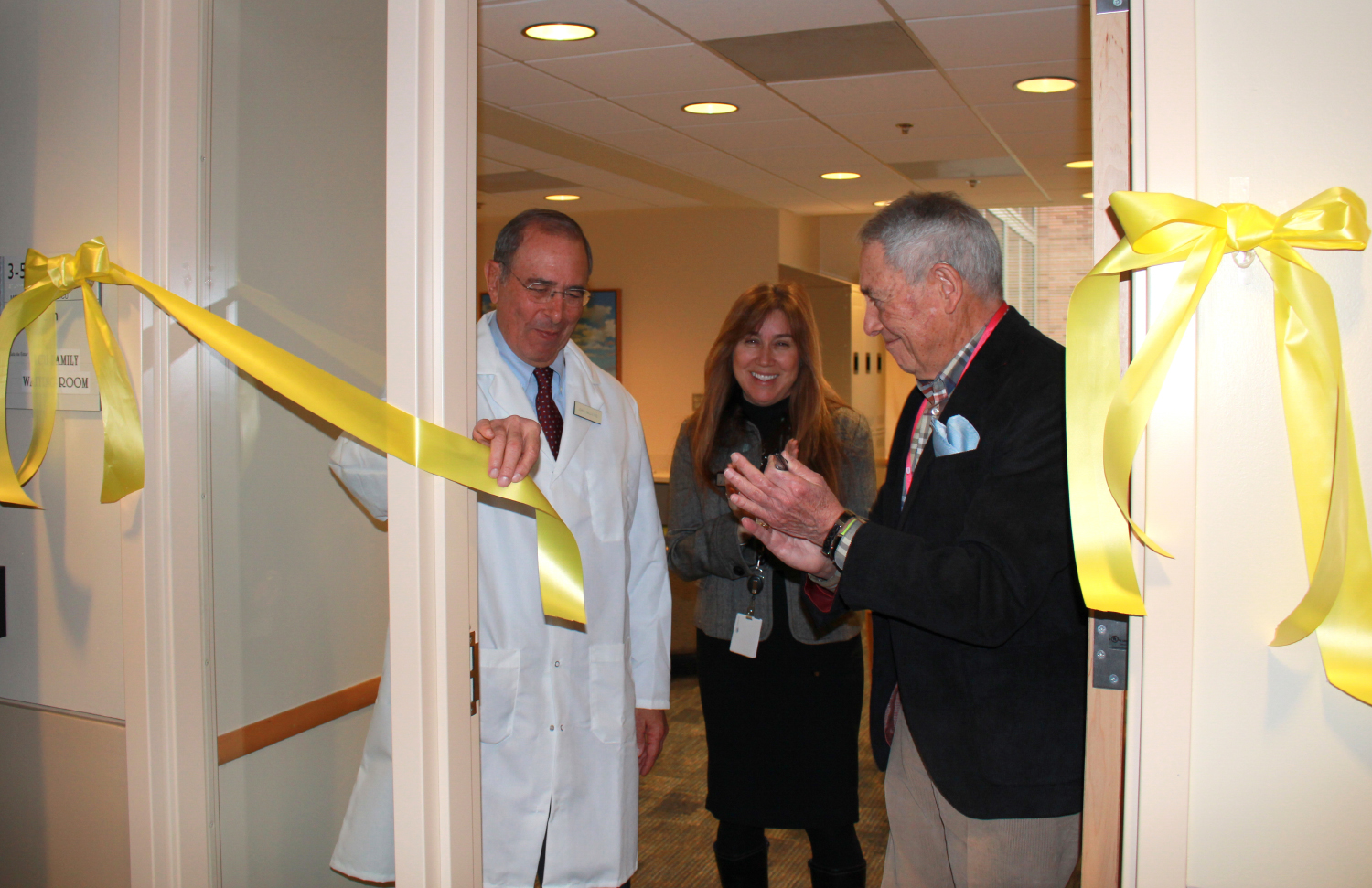 Dr. John I. Gallin, Heidi Grolig and a patient cut the ribbon.