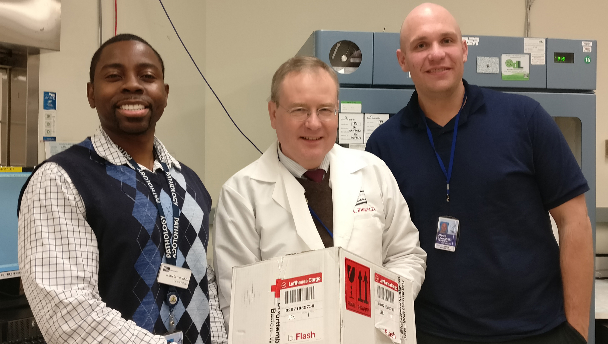 three doctors hold up a box