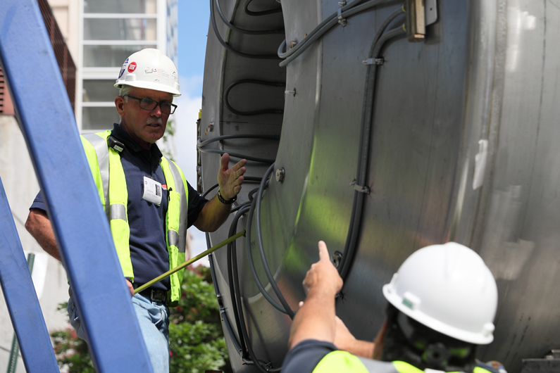 Two men up close to the MRI magnet, outside