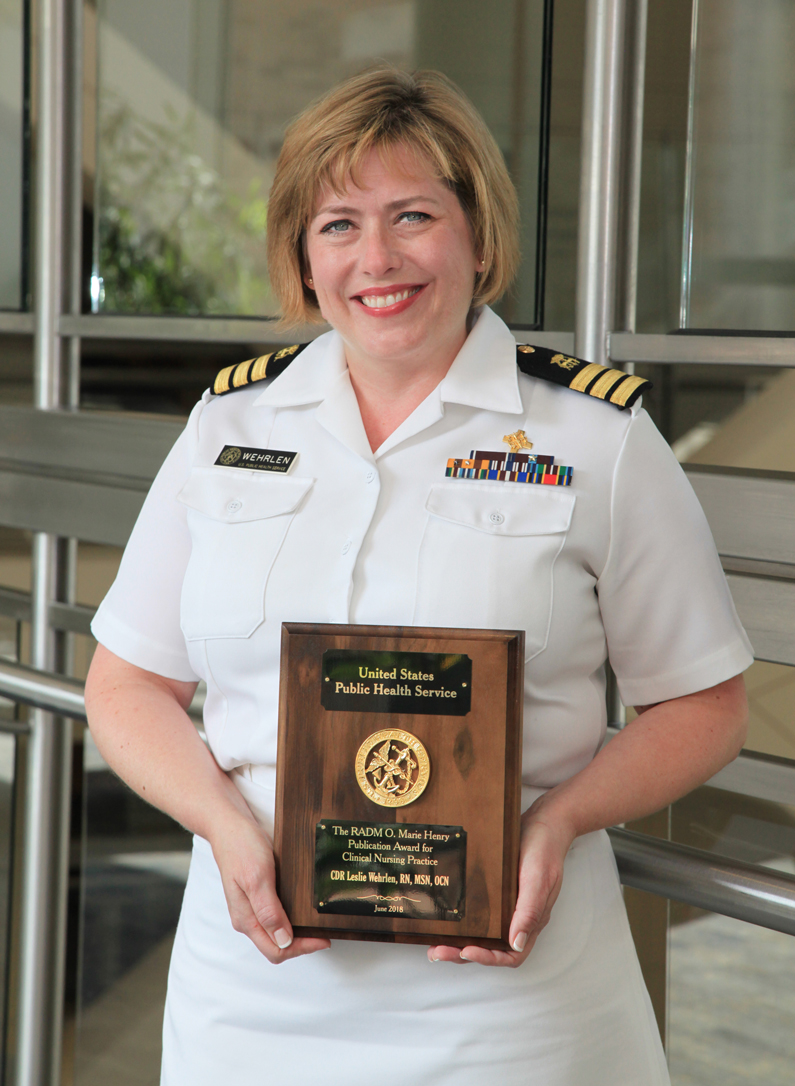 Leslie Wehrlen holds a plaque