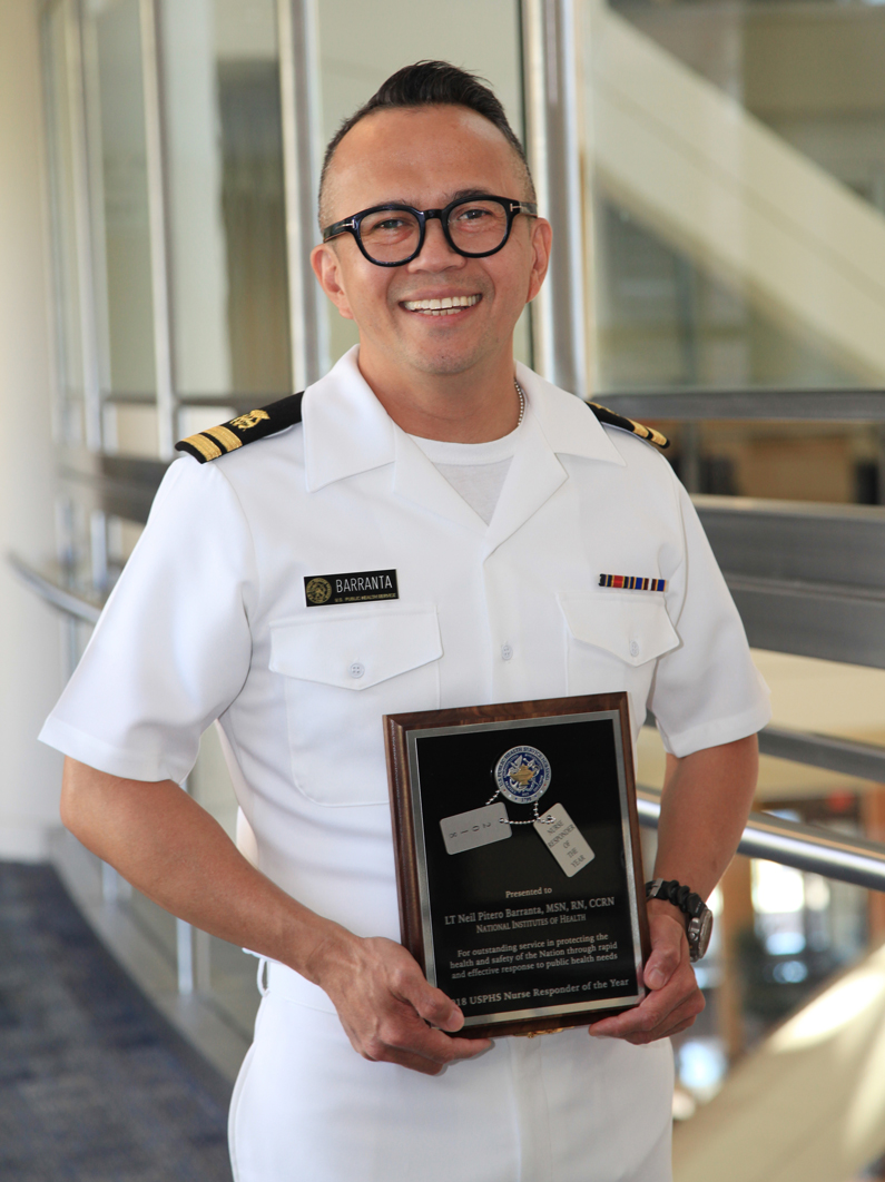 Neil Barranta holds a plaque