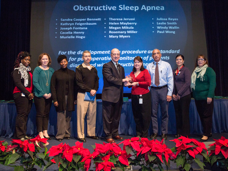 A group gathers on stage to receive an award