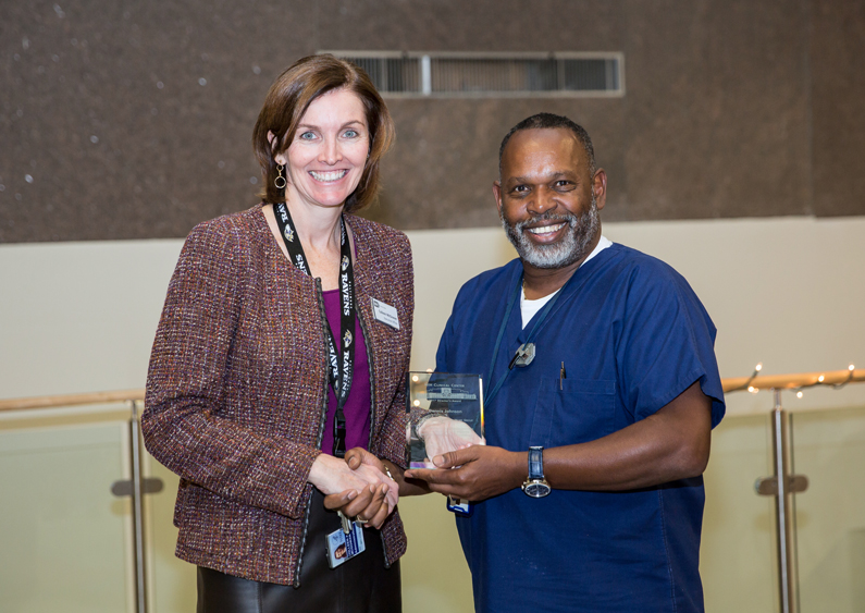 Colleen McGowan presents an award to Dennis Johnson