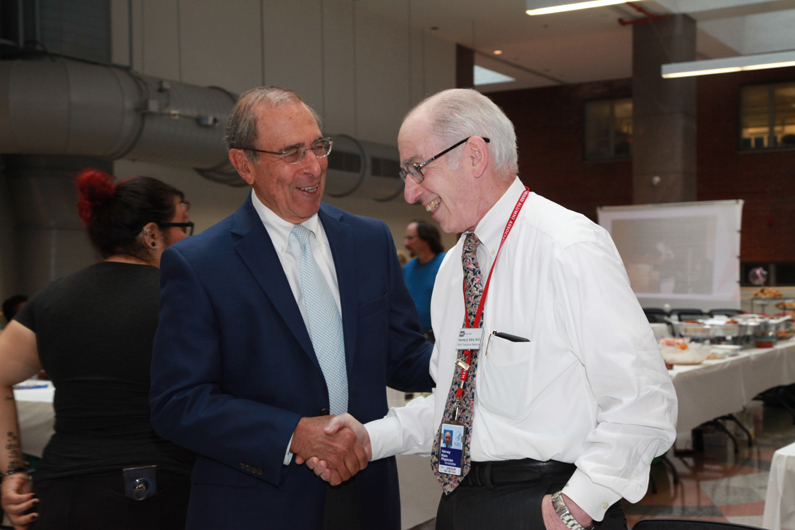 John I. Gallin shakes Dr. Harvey Klein's hand