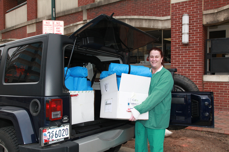 Carrie Wellen grabs a box filled with blankets from the back of her car. 