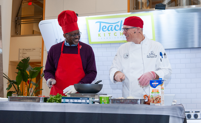 Two people prepare healthy dishes in the atrium