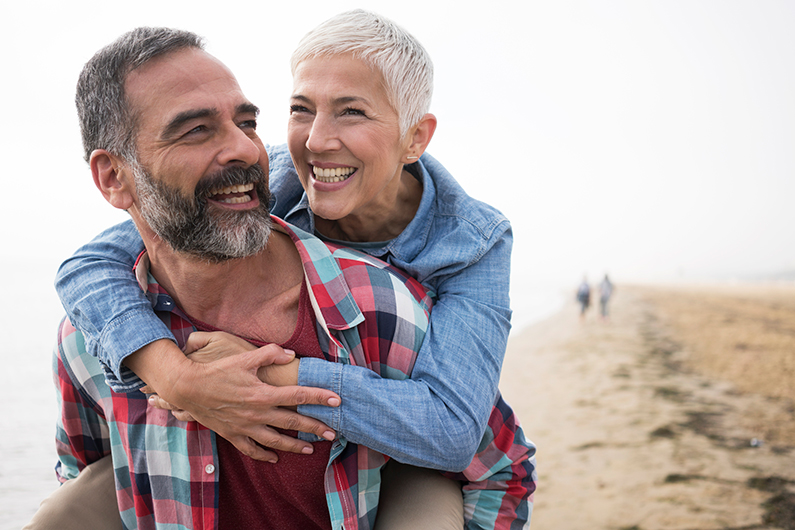 Couple smiling while walking on the beach