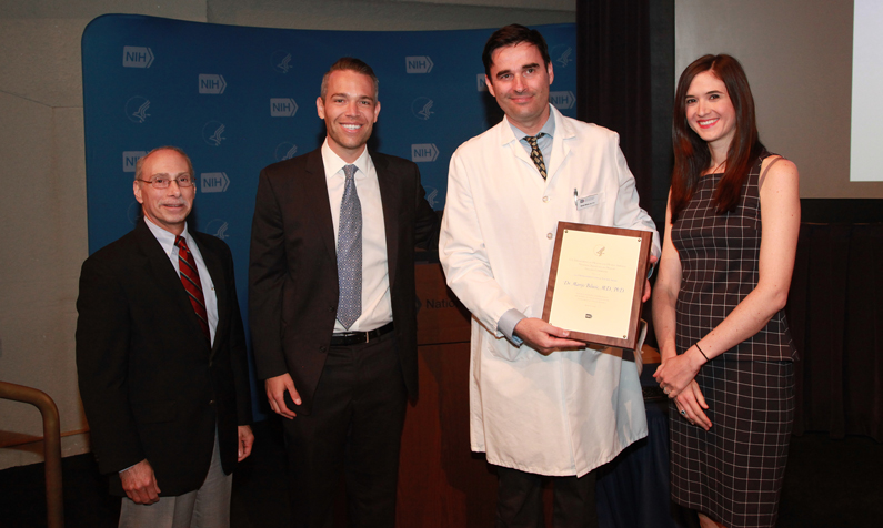 Dr. Marijo Bilusic holds a plaque, awarded by three others photographed