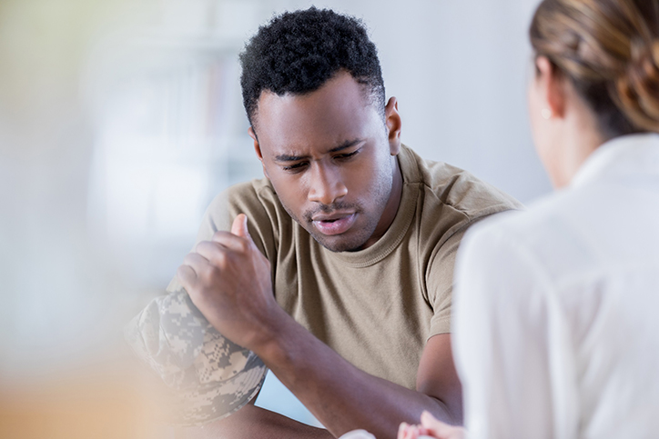 Man in fatigues talking to care provider