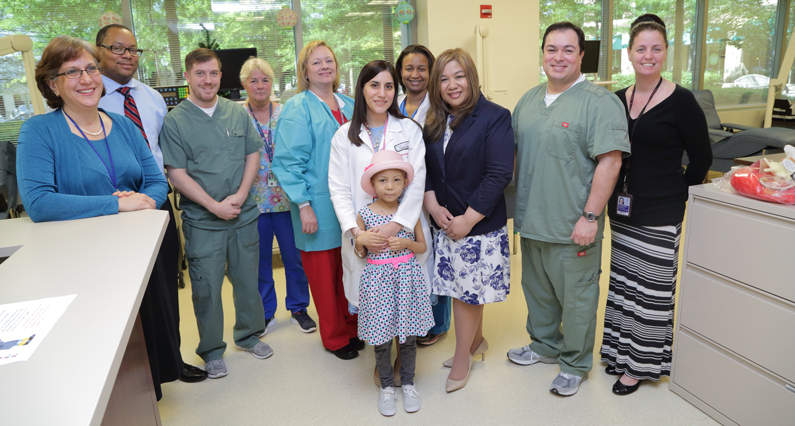 A pediatric patient with her mother and members of the NIH Blood Bank