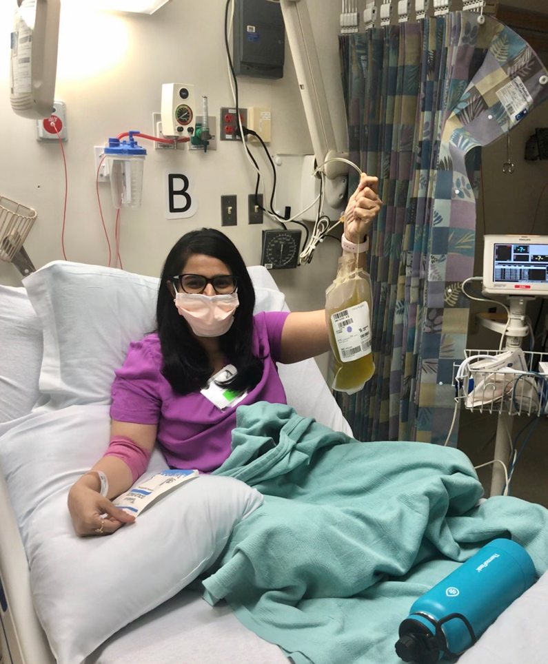 Healthy volunteer Tanvee Singh, holds plasma she's donating