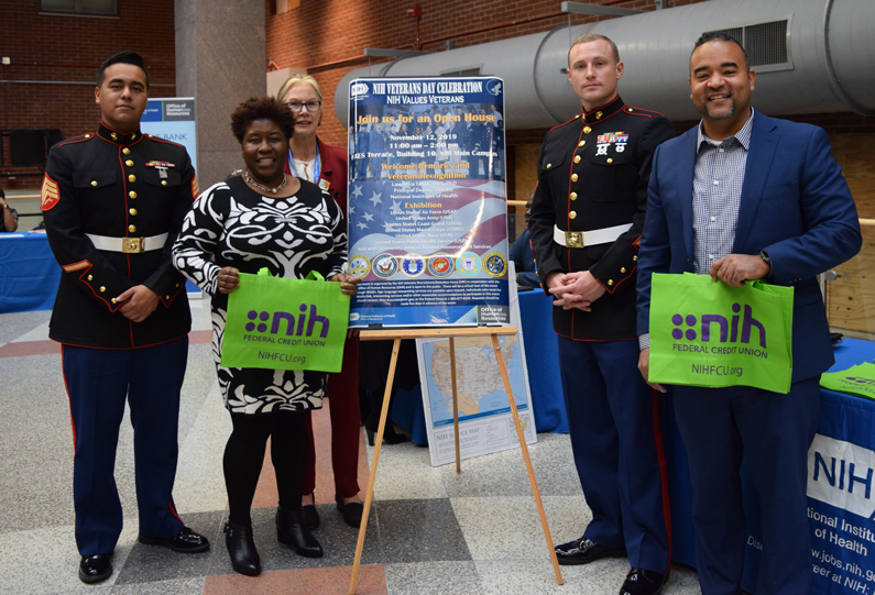 Ingrid Harris, Mitzi Kosciulek and Richard Appling pose with two Marines during NIH's 8th Annual Veterans Day Celebration Nov. 12