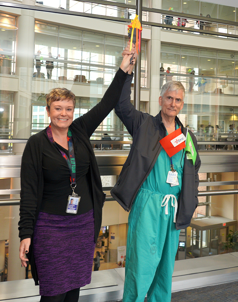 Kathy Baxley (left) and Dr. Andrew Mannes participate in CFC Torch Run as torchbearers