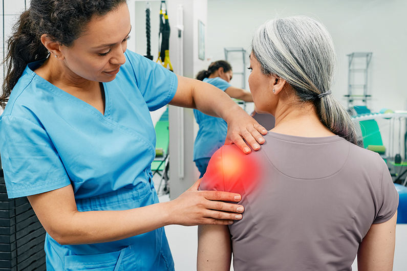 medical staff examining patient's sore shoulder