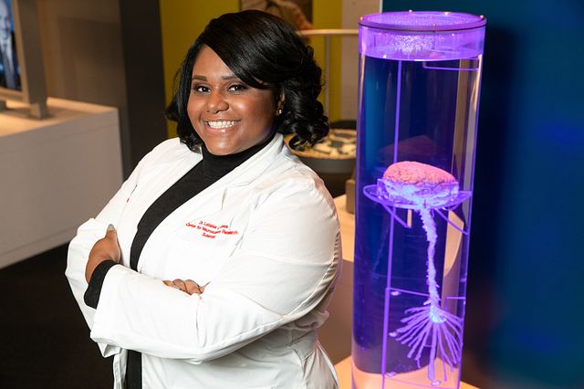 NIH researcher poses next to her statue.