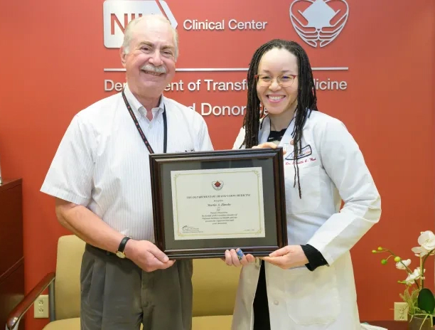 two NIH CC DTM staff members accepting an award