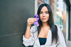 a woman holding up a ribbon