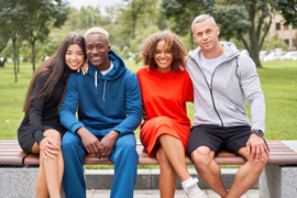 a group of people sitting on a bench smiling