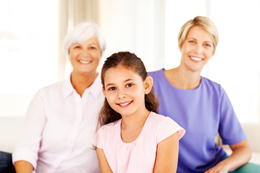 A grandmother, mother and daughter smiling