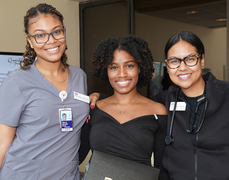 three smiling women posing together