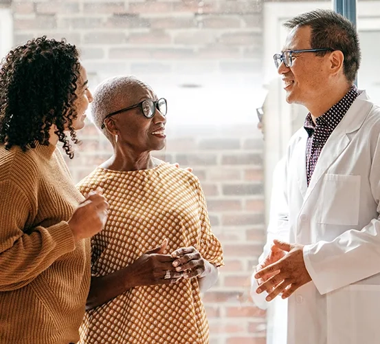 Physician discussing a treatment plan with 2 patients