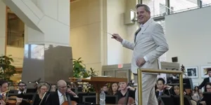 Steven Reineke conducting The National Symphony Orchestra in the NIH Clinical Center Atrium