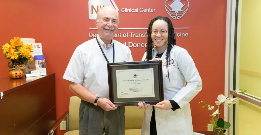 Marty, or "Mr. 300," as he's become known, is presented an award for his dedication to the blood donation program at the NIH Clinical Center.